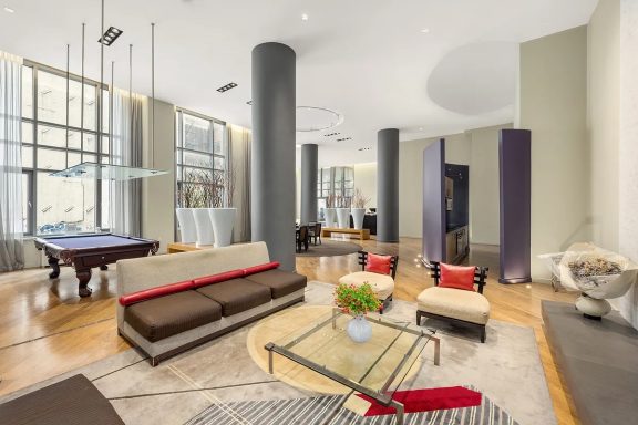 Spa club lounge Modern living room with a pool table, stylish furniture, and natural light.