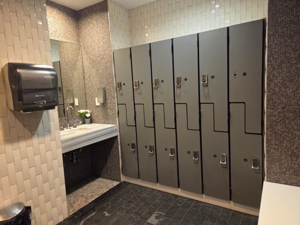 Locker room Restroom with lockers, sink, mirror, and hand dryer on the wall.