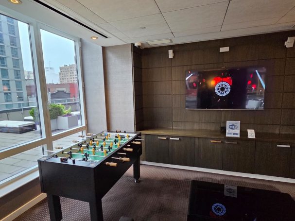 Foosball table A modern lounge area featuring a foosball table and a wall-mounted TV.