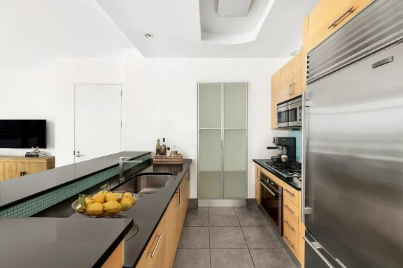Open kitchen Modern kitchen with wooden cabinetry, sleek countertops, and stainless steel appliances.
