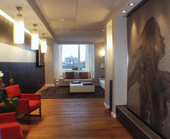 Spa lounge area Modern lobby with red chairs, a flat-screen TV, and a large wall art piece.