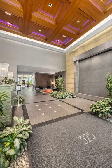 Lobby Modern indoor lobby featuring a wooden ceiling, plants, and a sleek drop-off area.