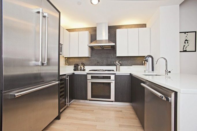 Lux Chef Kitchen Modern kitchen with stainless steel appliances, white cabinets, and wooden flooring.